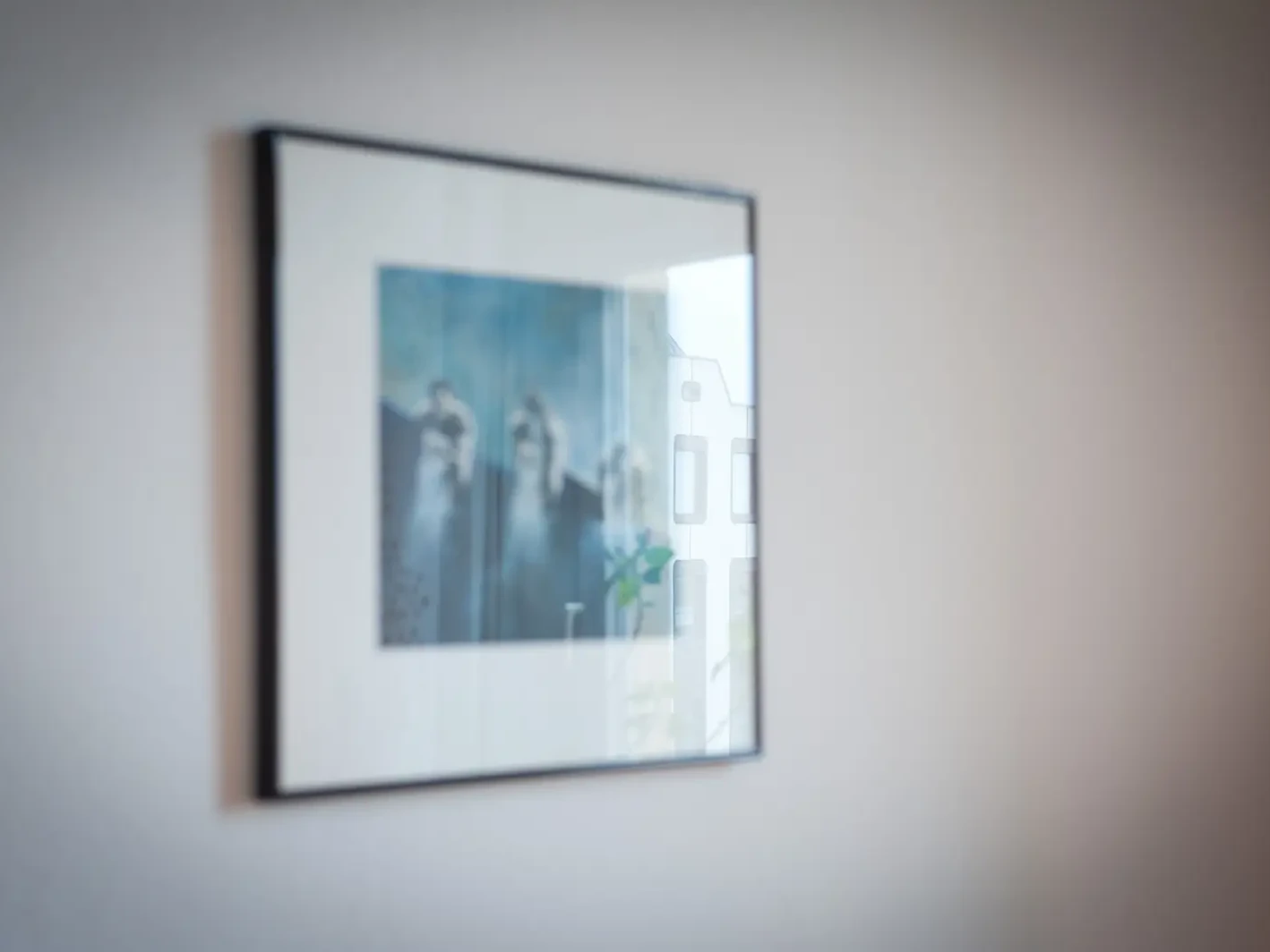 Gerahmtes Bild mit blauen Farbtönen an der Wand im Praxisraum